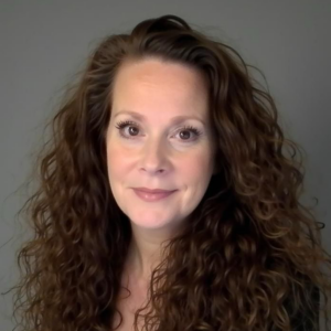 A woman with long brown hair and a smile.
