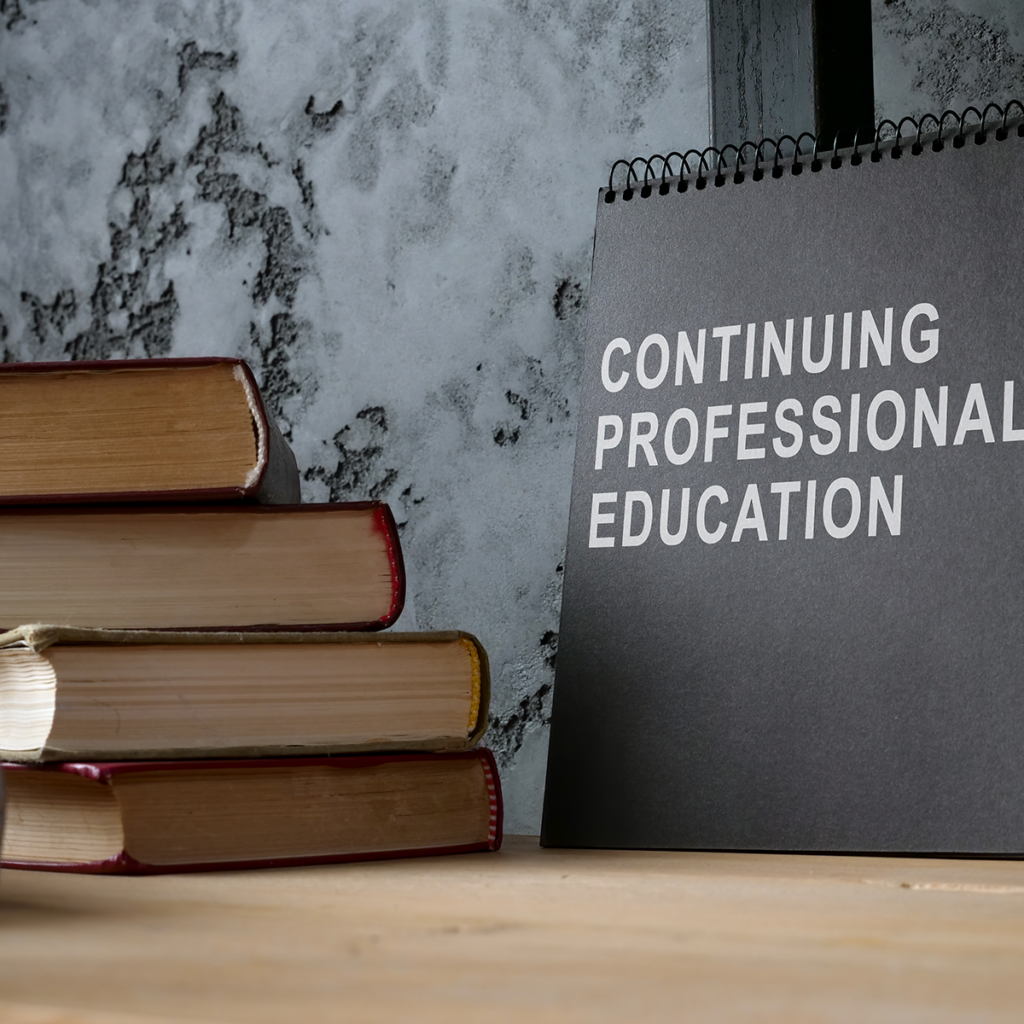 A stack of books next to a calendar.