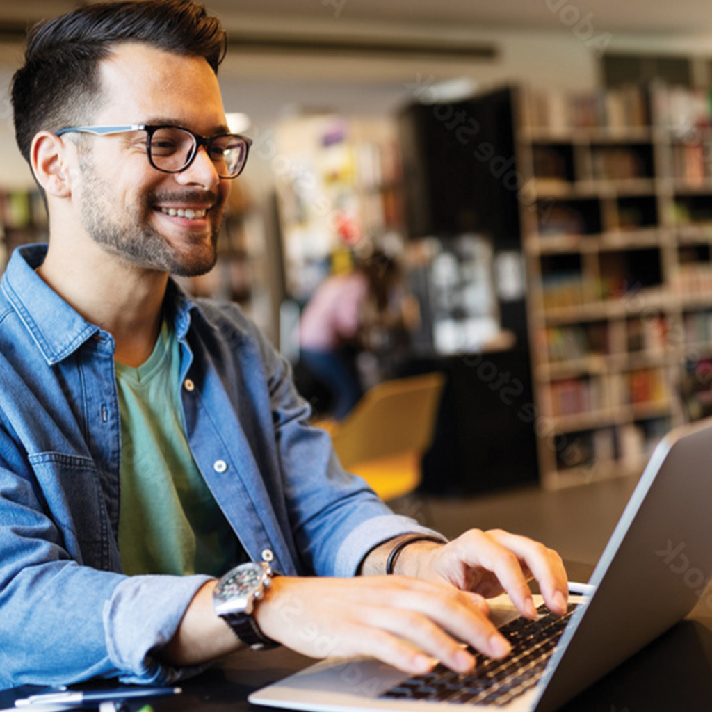 A man sitting at a table with a laptop.