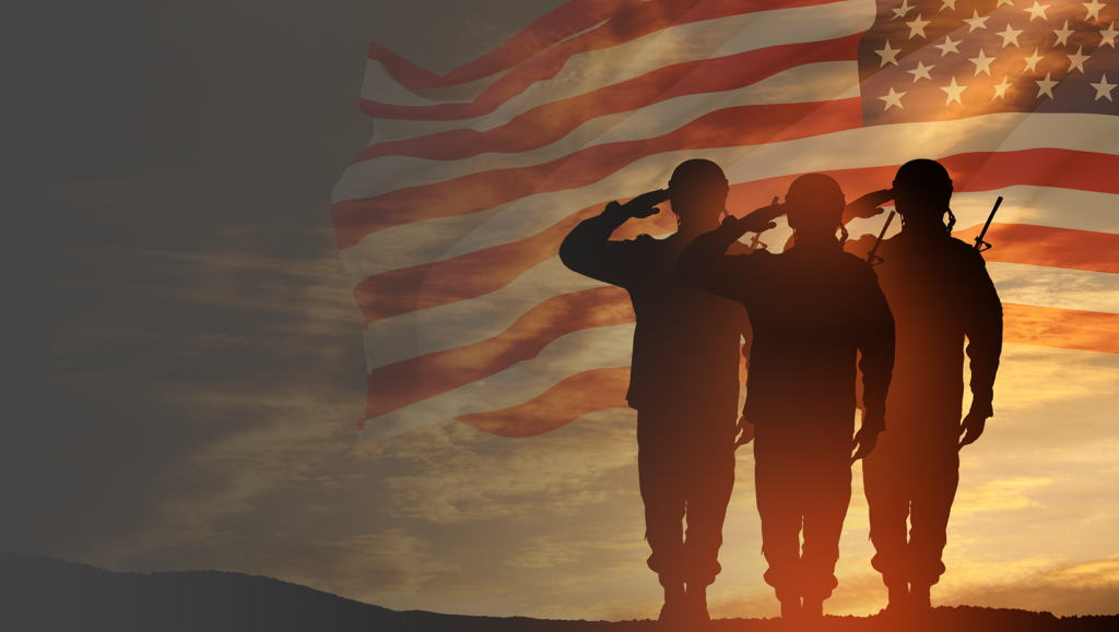 Two men saluting in front of an american flag.